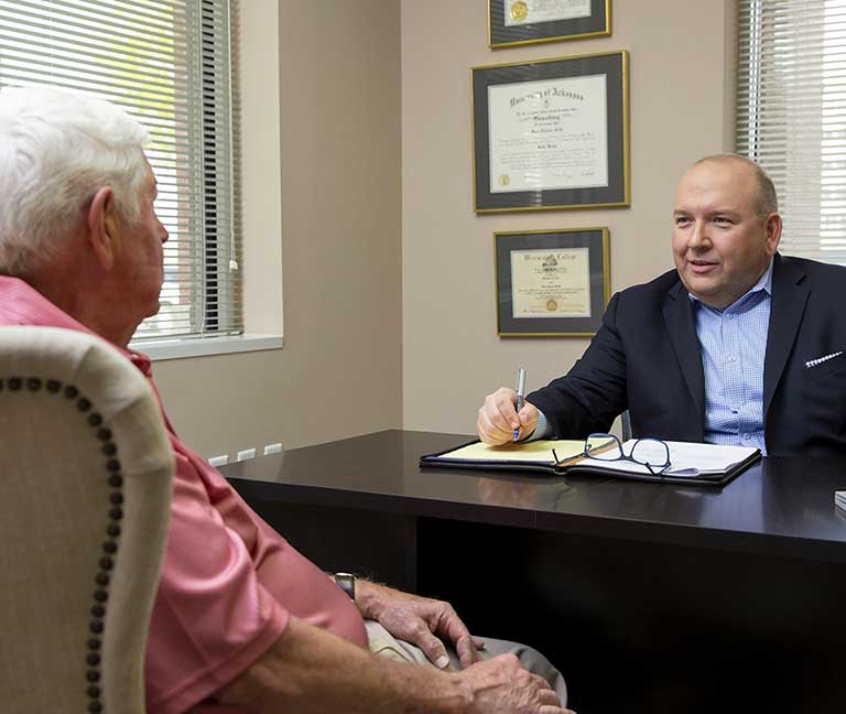 Sean meeting with an elderly client in his office